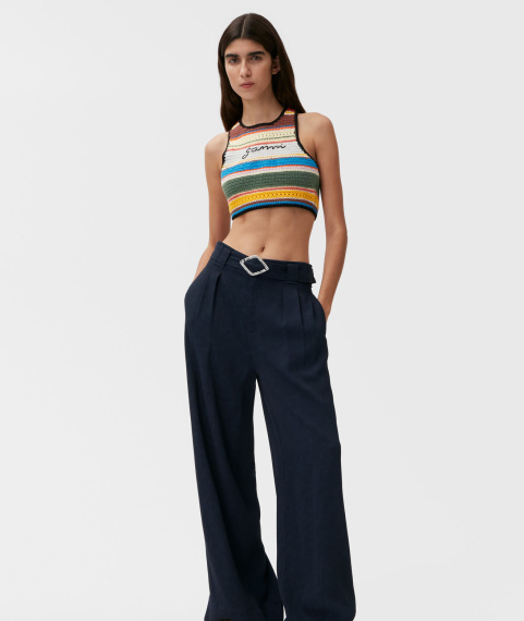 Model wearing GANNI embroirdered top and navy pants made with Circulose®