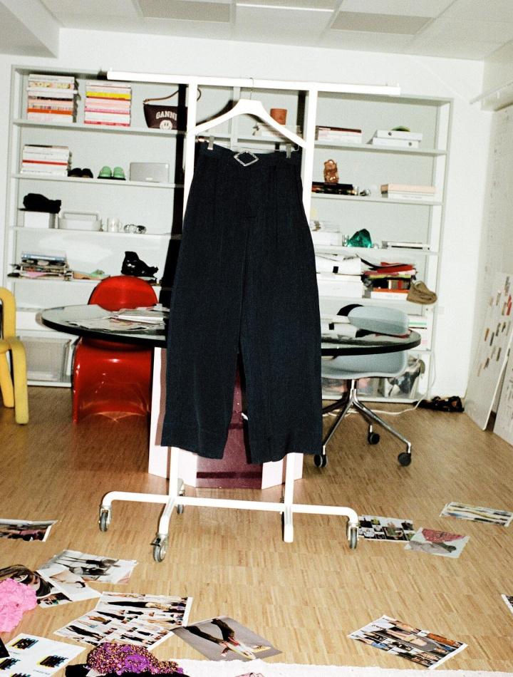 navy pants made with recycled circulose® material hanging in a room filled with vintage accessories and polaroids