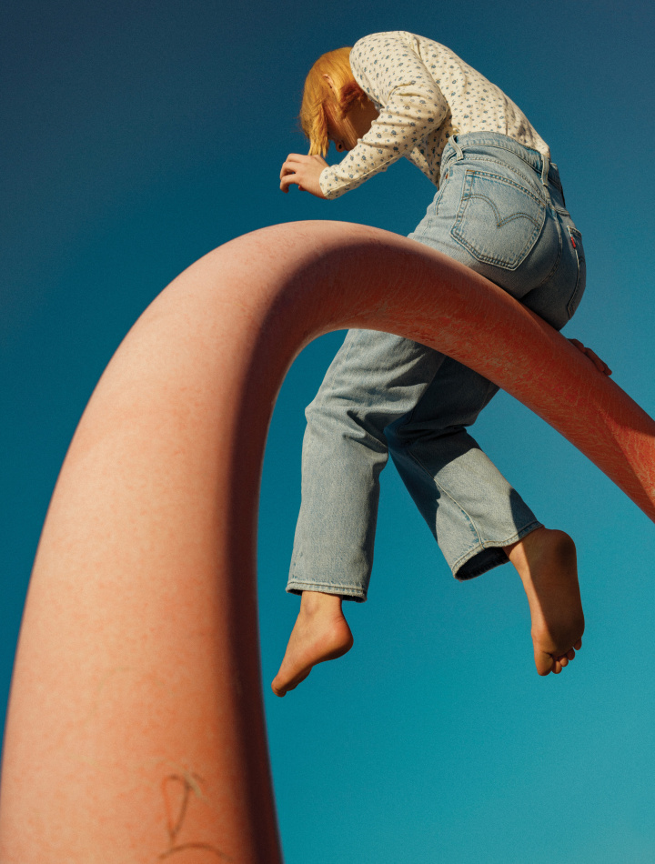 girl wearing levi's denim sitting on a high beam